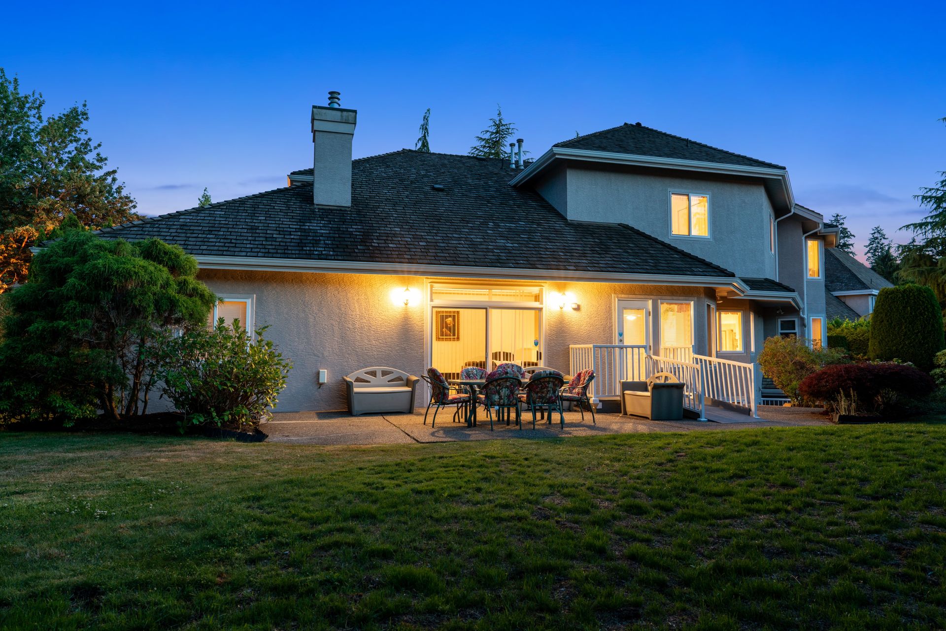 Twilight view of the back of the home and the lawn