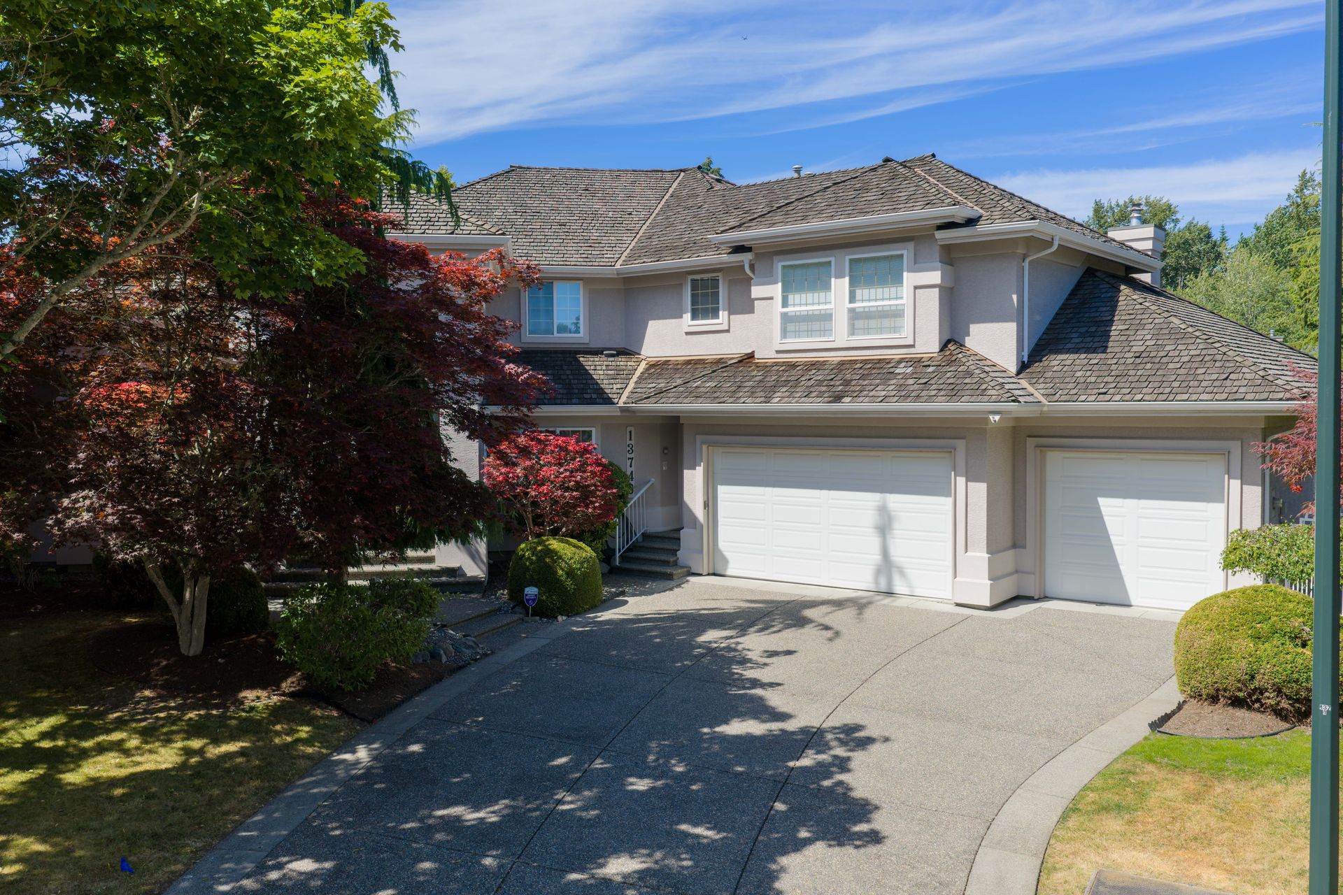 Front exterior and driveway on a sunny day