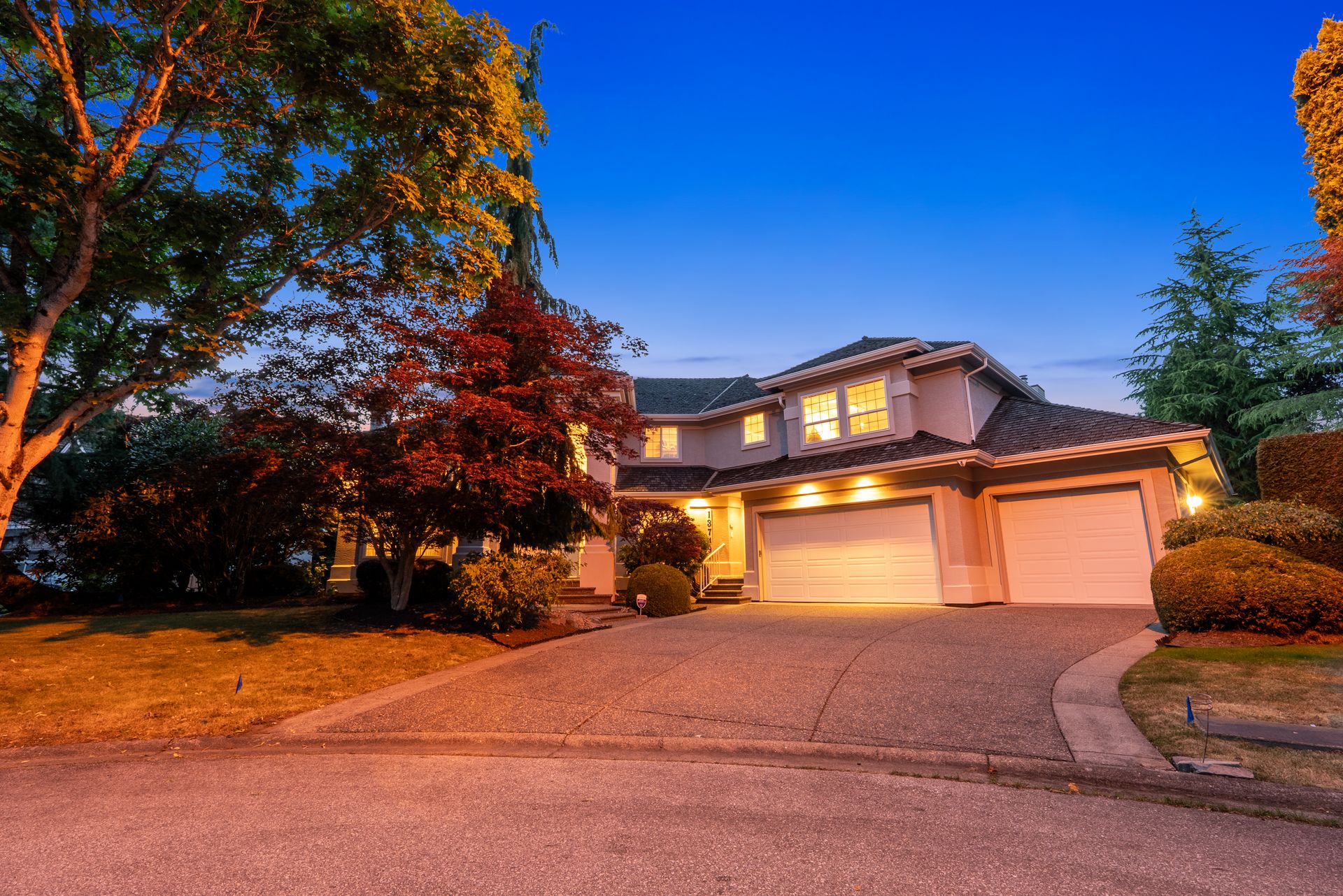 Twilight view of the driveway and the front of the home